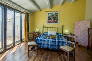 a bedroom with a bed and two chairs at Tenuta Arangio Agriturismo Vendicari in Casa Maccari +78 photos