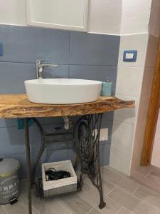 a bathroom with a sink on a wooden table at CASA MURALES Gianfranco in Murta Maria