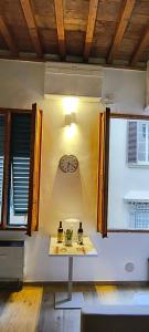 Una mesa en una habitación con un reloj en la pared. en Bobohouse, en Florencia 46 fotos más