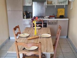 eine Küche mit einem Holztisch mit Stühlen und einem Tisch in der Unterkunft Gîte familial à la ferme avec activités nature - FR-1-489-454 in La Chabanne + 3 Fotos