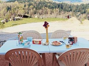 ein blauer Tisch mit Essen und Blumen drauf in der Unterkunft Gîte familial à la ferme avec activités nature - FR-1-489-454 in La Chabanne