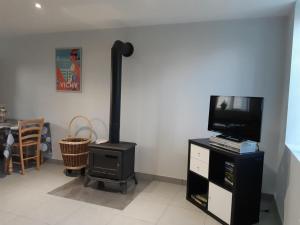 a wood stove in a living room with a tv at Charmante fermette en montagne bourbonnaise, animaux admis - FR-1-489-136 in Lavoine