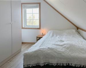 a white bedroom with a bed and a window at Cozy Cabin With Archipelago View, Kragerø in Stabbestad