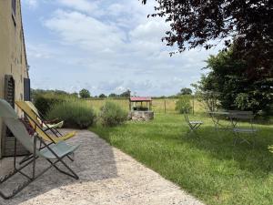 a group of chairs and a gazebo in a field at Charmante fermette avec animaux admis à Bourbon-l'Archambault - FR-1-489-87 in Bourbon-lʼArchambault