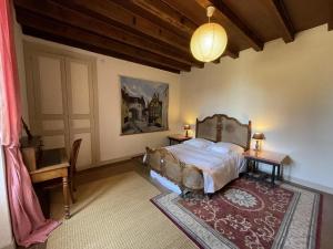 a bedroom with a bed and a table and a lamp at Grande Ferme avec Piscine Privative et Jardin, Proche Étang, Chappes - FR-1-489-90 in Chappes +16 photos