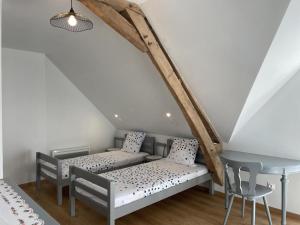 Pokój z dwoma łóżkami i stołem w obiekcie Charmant gîte à la ferme avec tout confort, proche de Bourbon-l'Archambault, idéal pour randos et curistes - FR-1-489-432 w mieście Ygrande