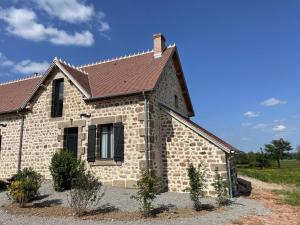 mały kamienny dom z brązowym dachem w obiekcie Charmant gîte à la ferme avec tout confort, proche de Bourbon-l'Archambault, idéal pour randos et curistes - FR-1-489-432 w mieście Ygrande