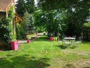 a yard with a table and chairs in the grass at Maison rénovée avec parc, piscine partagée et activités pour enfants - Draps et linge offerts - FR-1-489-324 in Moulins