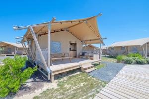 a tent with a wooden porch in a yard at Chincoteague Bay RV Resort & Cottages in Chincoteague