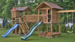 Apartamenty u Piekorza في شافلاري: ملعب خشبي مع منزلقين وبيت لعب