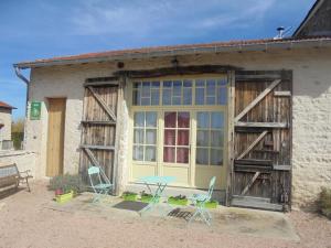 a table and chairs in front of a building at Gîte Écologique Confortable avec Jardin et Animaux Acceptés - FR-1-489-181 in Saint-Bonnet-de-Rochefort