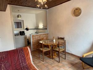 une salle à manger avec une table et une cuisine dans l'établissement Maison vignoble avec terrasse et BBQ à Saulcet, animaux admis - FR-1-489-544, à Saulcet