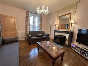 ein Wohnzimmer mit Sofa und Tisch in der Unterkunft Maison de caractère avec jardin et confort familial - FR-1-489-556 in Lurcy-Lévis