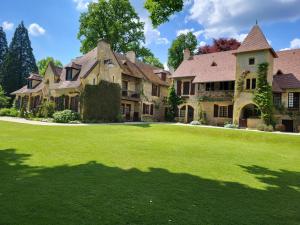 ein großes Haus mit einem großen Garten mit grünem Gras in der Unterkunft Maison de caractère avec jardin et confort familial - FR-1-489-556 in Lurcy-Lévis