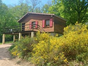 a cabin in the woods with a field of flowers at Chalet paisible avec jardin et wifi à Jenzat - FR-1-489-564 in Jenzat