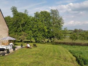 a garden with a table and chairs and a grill at Gîte nature à St Léon avec jardin et WIFI - FR-1-489-440 in Saint-Léon