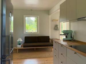 a living room with a couch and a window at Modern Holiday Home Close To Odden Beach in Tjørneholm +19 photos