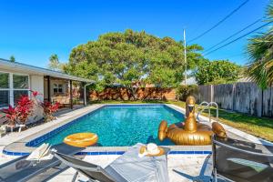 a swimming pool in a yard with chairs and a house at 721 Java Rd in Cocoa Beach
