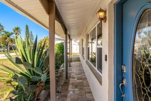 a porch of a house with plants and a blue door at 721 Java Rd in Cocoa Beach