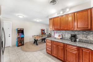 a kitchen with wooden cabinets and a ping pong table at 721 Java Rd in Cocoa Beach