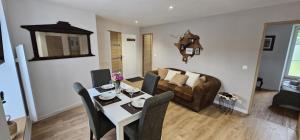 a living room with a table and a couch at L'Alberta appartement Genainville in Génainville