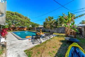 a backyard with a swimming pool and chairs at 721 Java Rd in Cocoa Beach