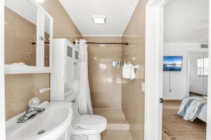 a bathroom with a sink and a toilet and a shower at 721 Java Rd in Cocoa Beach