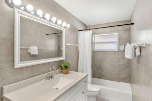 a bathroom with a sink and a toilet and a mirror at 721 Java Rd in Cocoa Beach