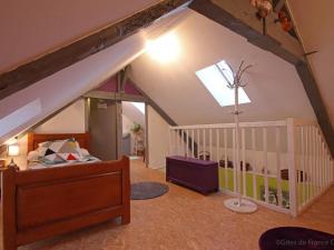 a attic room with a bed and a staircase at Gîte familial tout confort avec jeux et jardin, proche voie verte et rivière - FR-1-497-132 in Dompierre