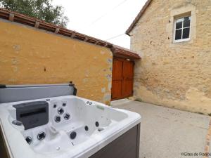 une baignoire blanche située à l'extérieur d'un bâtiment dans l'établissement Spacieuse longère Percheronne avec jardin et spa extérieur - FR-1-497-138, à Corbon