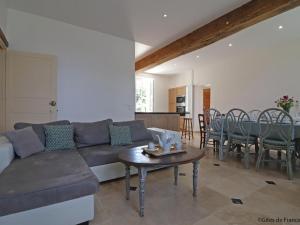 un salon avec un canapé et une table dans l'établissement Spacieuse longère Percheronne avec jardin et spa extérieur - FR-1-497-138, à Corbon