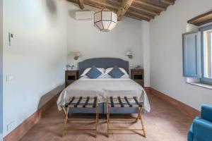 a bedroom with a bed with blue pillows at Historic Villa Overlooking Val D'orcia in Buonconvento