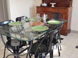 a glass table with green plates on top of it at Gîte cosy avec terrasse et WiFi - 2 ch, 4 pers à Besson - FR-1-489-355 in Besson +15 photos
