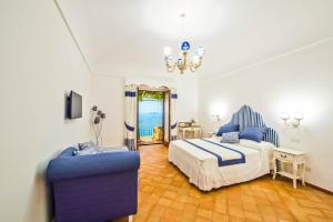 a bedroom with a bed and a blue chair at Casa Cinque in Positano