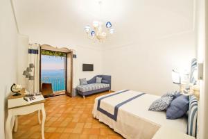 a bedroom with a bed and a couch and a window at Casa Cinque in Positano +7 photos