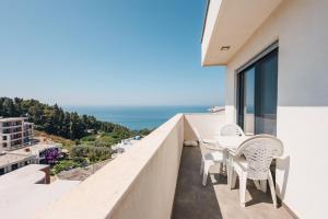 a balcony with a table and chairs overlooking the ocean at Apartment L'ideal in Ulcinj