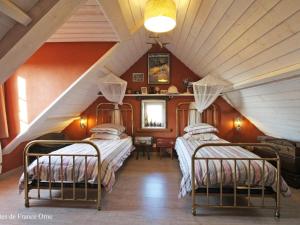 two beds in a room with an attic at Maison 6 pers avec sauna et jardin, Suisse Normande - FR-1-497-172 in Bréel