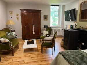 a bedroom with a living room with a couch and chairs at Gîte de charme à Souvigny avec jardin et animaux acceptés - FR-1-489-583 in Souvigny