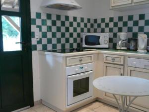 una cucina con piano cottura bianco e forno a microonde di Maison individuelle à Contres avec piscine partagée - FR-1-491-465 a Le Controis En Sologne