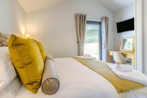 Un dormitorio con una gran cama blanca con almohadas amarillas. en 2 Bed in Cemmaes oc-a32660, en Cemmaes