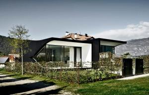a black and white house with a fence at Designer South Side Apartment In The Dolomites in Bolzano