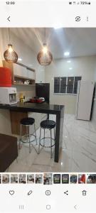 a kitchen with a table and two stools in it at Ótimo Apartamento 2 quartos mobiliado in Silvânia