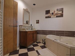 a bathroom with a tub and a sink and a bath tub at Maison authentique avec jardin et terrasse en Normandie, animaux acceptés - FR-1-497-142 in Céaucé +28 photos