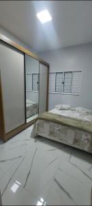 a bedroom with a large bed and large windows at Ótimo Apartamento 2 quartos mobiliado in Silvânia