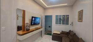a living room with a couch and a flat screen tv at Ótimo Apartamento 2 quartos mobiliado in Silvânia