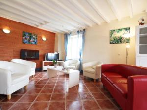 sala de estar con muebles blancos y sofá rojo en Maison familiale avec jardin clos, jeux extérieurs, wifi et tout confort au cœur du Parc du Perche - FR-1-497-10, en Feings