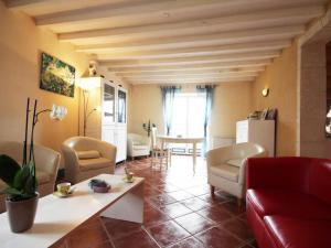 Una sala de estar con un sofá rojo y una mesa. en Maison familiale avec jardin clos, jeux extérieurs, wifi et tout confort au cœur du Parc du Perche - FR-1-497-10, en Feings