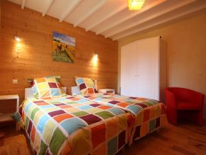 Un dormitorio con una cama y una silla roja. en Maison familiale avec jardin clos, jeux extérieurs, wifi et tout confort au cœur du Parc du Perche - FR-1-497-10, en Feings