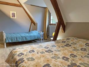 a bedroom with a bed with a comforter at Manoir du XVème avec cheminée, animaux acceptés, à Colombiers - FR-1-497-204 in Colombiers