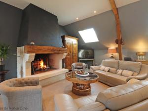 un salon avec un canapé et une cheminée dans l'établissement Charmante maison normande avec cheminée et jardin privé - FR-1-497-181, à Occagnes